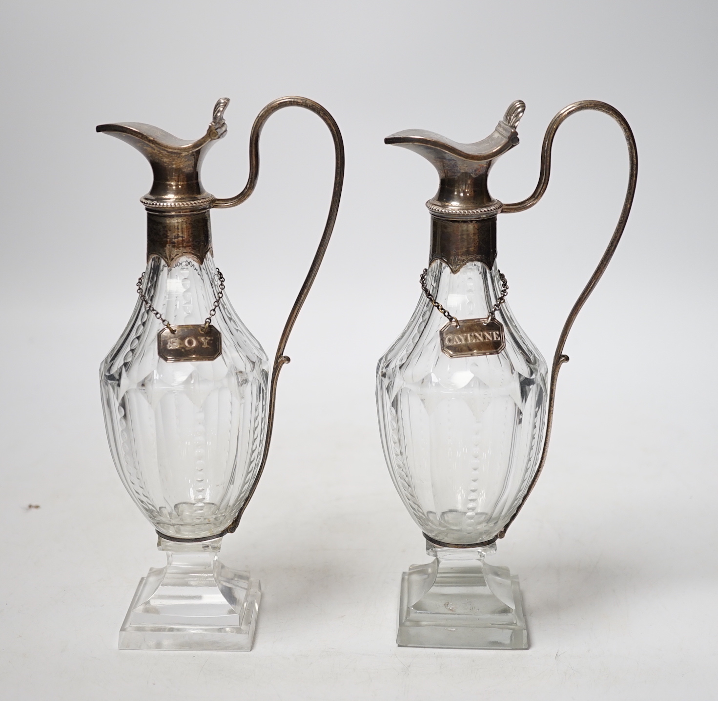 A pair of late 18th/early 19th century silver mounted cut glass cut glass cruet bottles with labels for Cayenne and Soy, makers mark only on mounts and labels for Phipps & Robinson, circa, 1800, height 20.5cm.